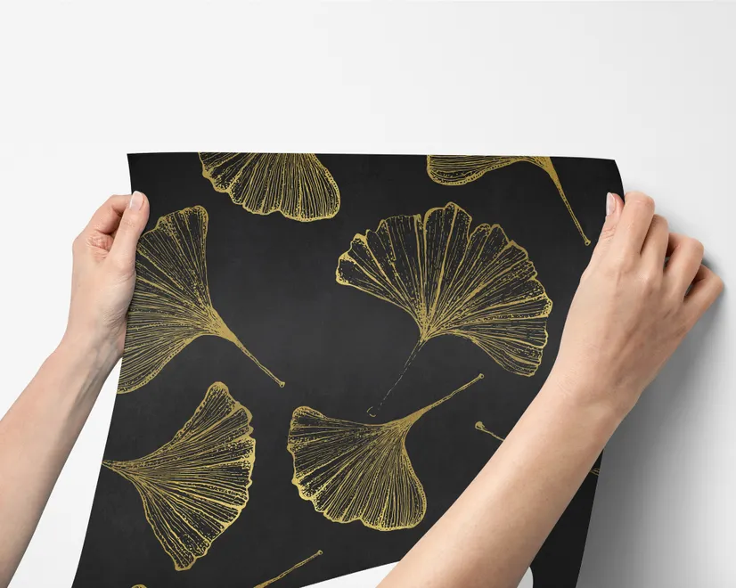 Black wallpaper with antique metallic gold ginkgo leaves on a mottled charcoal ground