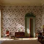 Cute pink wallpaper with birds, tan branches, green leaves and ivory, coral and lilac flowers.