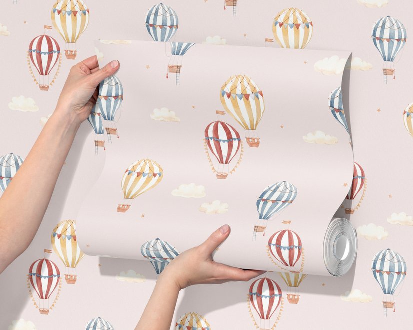 Hot air balloon nursery room wallpaper with watercolour balloons, clouds and stars on a soft blush-pink ground