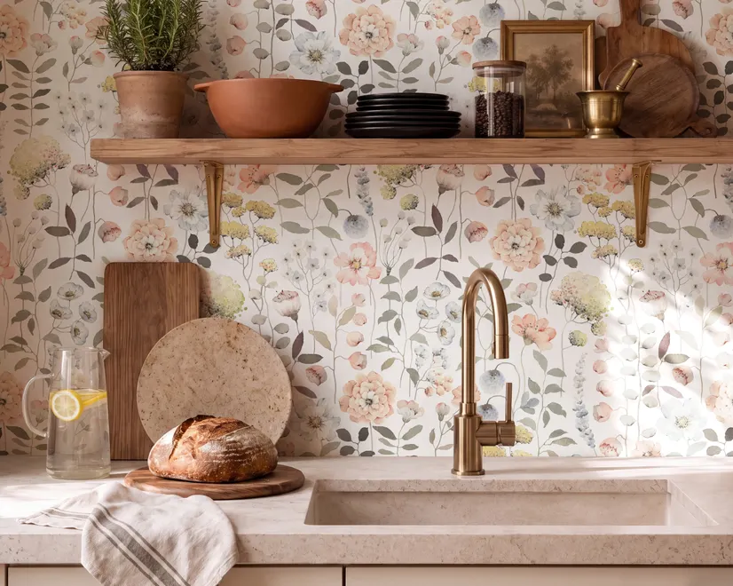 Watercolour wildflower wallpaper with pastel flowers and sage leaves on a white ground