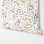 Watercolour wildflower wallpaper with pastel flowers and sage leaves on a white ground