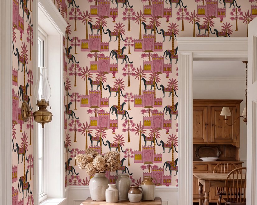 Tropical foliage wallpaper with black panthers, pink palace facades and ochre palms on pale peach