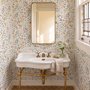 Watercolour wildflower wallpaper with pastel flowers and sage leaves on a white ground