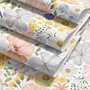 Spring floral wallpaper with pastel watercolour flowers and sage leaves on a clean white ground