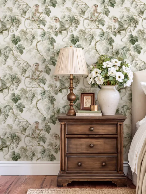 Vintage nature wallpaper with pale monkeys, sage grape leaves, white grape clusters and taupe vines on ivory.