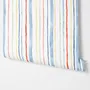 Blue and light blue wallpaper with hand-painted vertical watercolour stripes on a clean white ground
