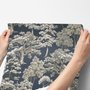 Navy wallpaper with warm ivory and taupe grey toile tree repeat on deep slate blue ground
