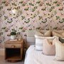 Cute pink wallpaper with birds, tan branches, green leaves and ivory, coral and lilac flowers.