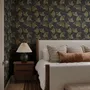 Black wallpaper with antique metallic gold ginkgo leaves on a mottled charcoal ground