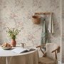 Pink chinoiserie wallpaper with watercolor flowers, blue-grey leaves and red berries on a cream linen-texture ground