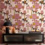 Tropical foliage wallpaper with black panthers, pink palace facades and ochre palms on pale peach