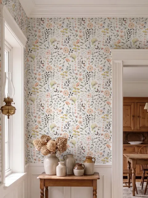 Watercolour wildflower wallpaper with pastel flowers and sage leaves on a white ground