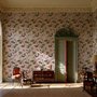 Cute pink wallpaper with birds, tan branches, green leaves and ivory, coral and lilac flowers.