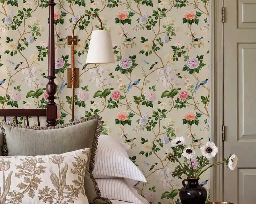 Chinoiserie wallpaper with blue-grey birds, pink peonies, white orchids and green branches on ivory-cream ground