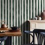Green striped minimalist wallpaper with vertical deep forest green bands on a soft warm ivory ground.