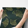 Dark green wallpaper with metallic antique-gold etched ginkgo leaves on a textured forest-green teal ground