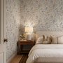 Watercolour wildflower wallpaper with pastel flowers and sage leaves on a white ground