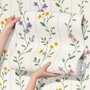 Cute floral wallpaper with green vine trails and pink, purple and yellow watercolor flowers on cream