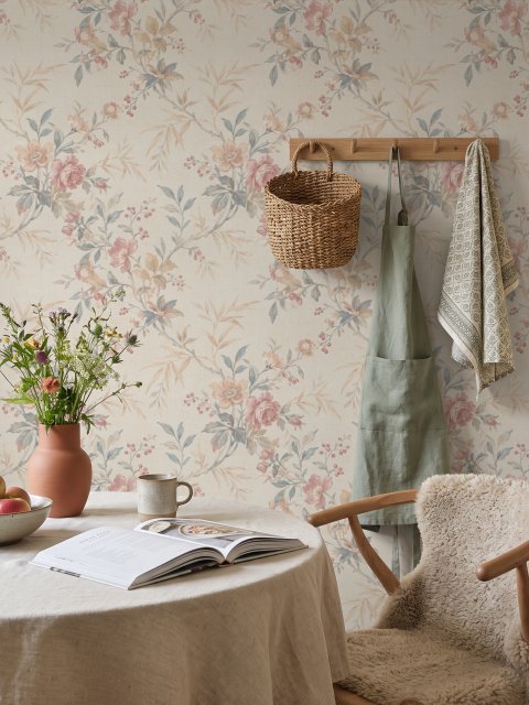 Pink chinoiserie wallpaper with watercolor flowers, blue-grey leaves and red berries on a cream linen-texture ground