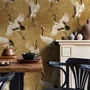 Japanese crane wallpaper with white, black and red cranes in flight on an antique-gold textured ground
