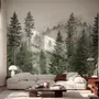 Misty mountain wallpaper mural with tall pine trees, layered green forest and pale foggy ridges