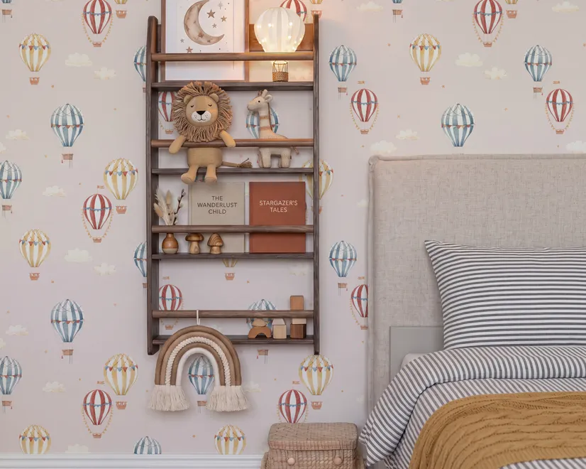 Hot air balloon nursery room wallpaper with watercolour balloons, clouds and stars on a soft blush-pink ground
