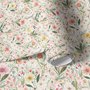 Pink wallpaper with watercolour blush, coral and yellow wildflowers, sage leaves and stems on a warm cream-white ground.