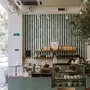 Green striped minimalist wallpaper with vertical deep forest green bands on a soft warm ivory ground.