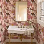 Tropical foliage wallpaper with black panthers, pink palace facades and ochre palms on pale peach
