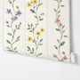 Cute floral wallpaper with green vine trails and pink, purple and yellow watercolor flowers on cream