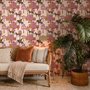 Tropical foliage wallpaper with black panthers, pink palace facades and ochre palms on pale peach