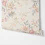 Pink chinoiserie wallpaper with watercolor flowers, blue-grey leaves and red berries on a cream linen-texture ground