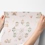 Children's playroom wallpaper with pastel Ferris wheel, carousel horses, tents and balloons on blush pink