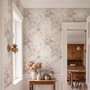Pink chinoiserie wallpaper with watercolor flowers, blue-grey leaves and red berries on a cream linen-texture ground