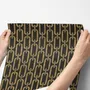 Black wallpaper with gold vertical chain link Art Deco repeat on a textured charcoal ground