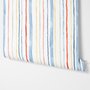 Blue and light blue wallpaper with hand-painted vertical watercolour stripes on a clean white ground