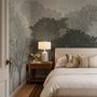 Light gray wallpaper mural with layered ink-wash woodland trees, falling leaves and birds