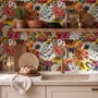 Floral and fish wallpaper with coral blooms, teal fish and black white flowers on metallic mustard-gold ground
