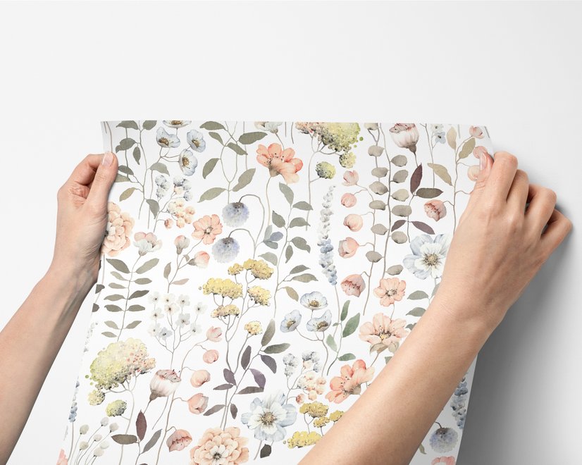Watercolour wildflower wallpaper with pastel flowers and sage leaves on a white ground
