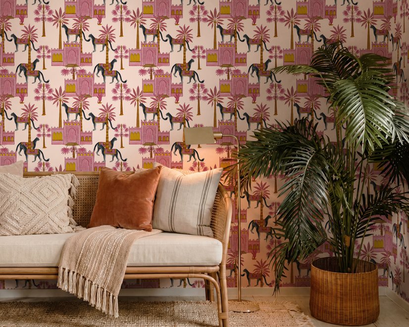 Tropical foliage wallpaper with black panthers, pink palace facades and ochre palms on pale peach