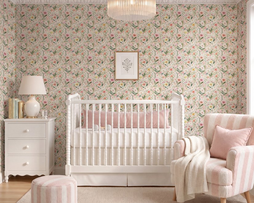 Pink wallpaper with watercolour blush, coral and yellow wildflowers, sage leaves and stems on a warm cream-white ground.
