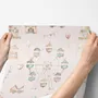 Children's playroom wallpaper with pastel Ferris wheel, carousel horses, tents and balloons on blush pink