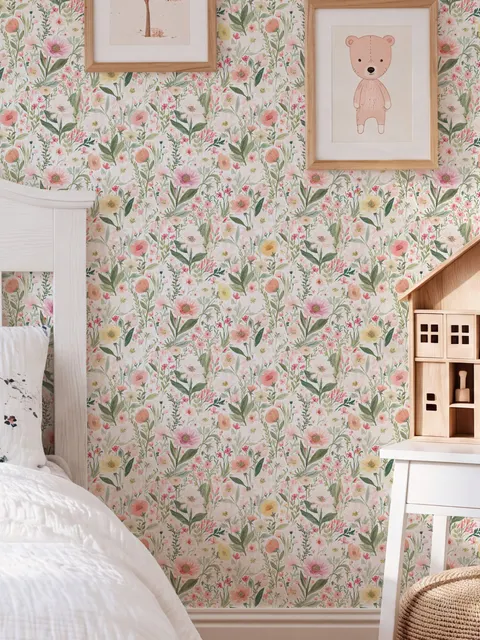 Pink wallpaper with watercolour blush, coral and yellow wildflowers, sage leaves and stems on a warm cream-white ground.