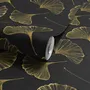 Black wallpaper with antique metallic gold ginkgo leaves on a mottled charcoal ground