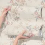 Pink chinoiserie wallpaper with watercolor flowers, blue-grey leaves and red berries on a cream linen-texture ground