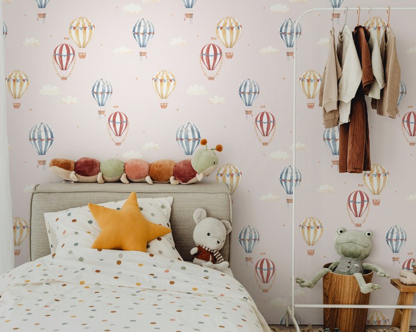 Hot air balloon nursery room wallpaper with watercolour balloons, clouds and stars on a soft blush-pink ground