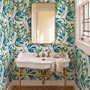 Dark olive green wallpaper with teal and cobalt watercolour lance leaves on a white ground