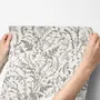 Black outline botanical wallpaper with charcoal wildflowers and grasses on a warm ivory cream ground