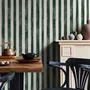 Green striped minimalist wallpaper with vertical deep forest green bands on a soft warm ivory ground.
