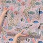Cute pink seashell wallpaper with watercolour reef fish, coral, seaweed, starfish and shells on blush pink